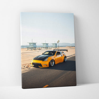 Vertical canvas art of yellow Nissan 370z sports car parked on beach road with lifeguard towers in background wall art.