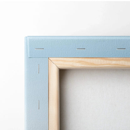 Close-up of wrapped light blue canvas with wooden frame and visible staples for wall art canvas print.