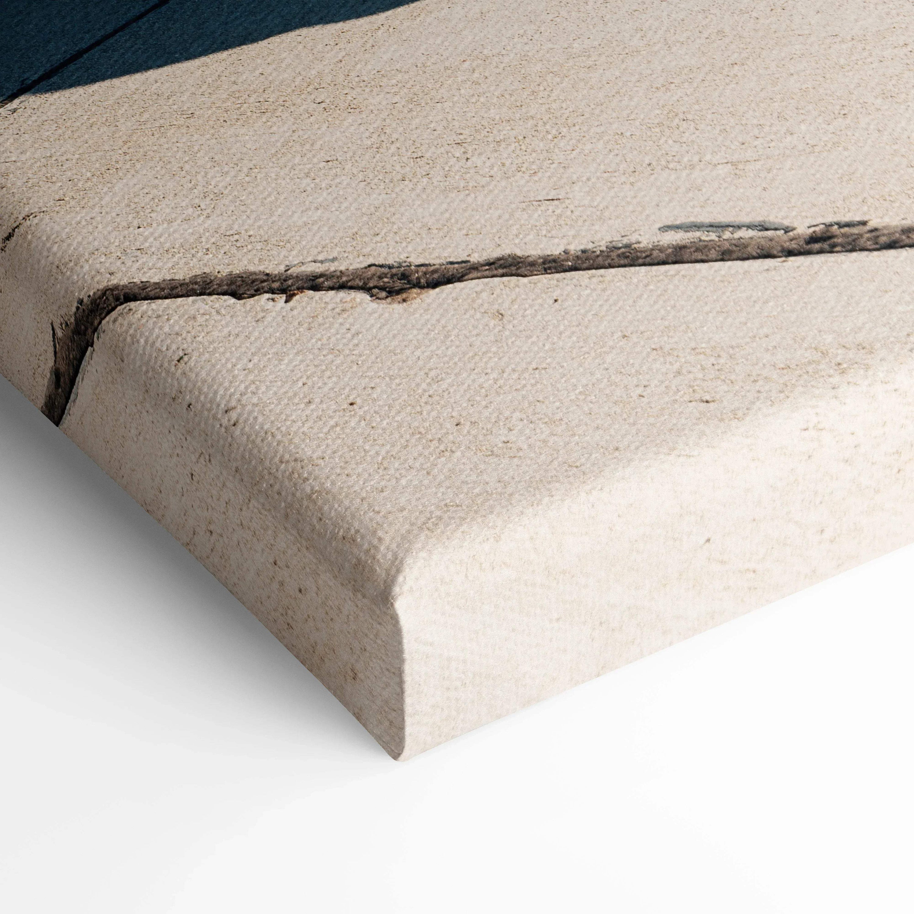 Close-up of textured canvas wall art corner with a subtle printed design on off-white fabric.