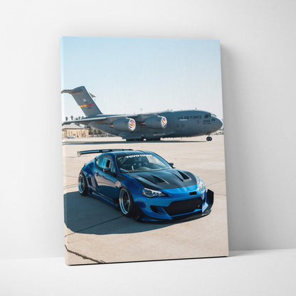 Blue Toyota FRS parked on runway with military cargo plane in background vertical canvas wall art.