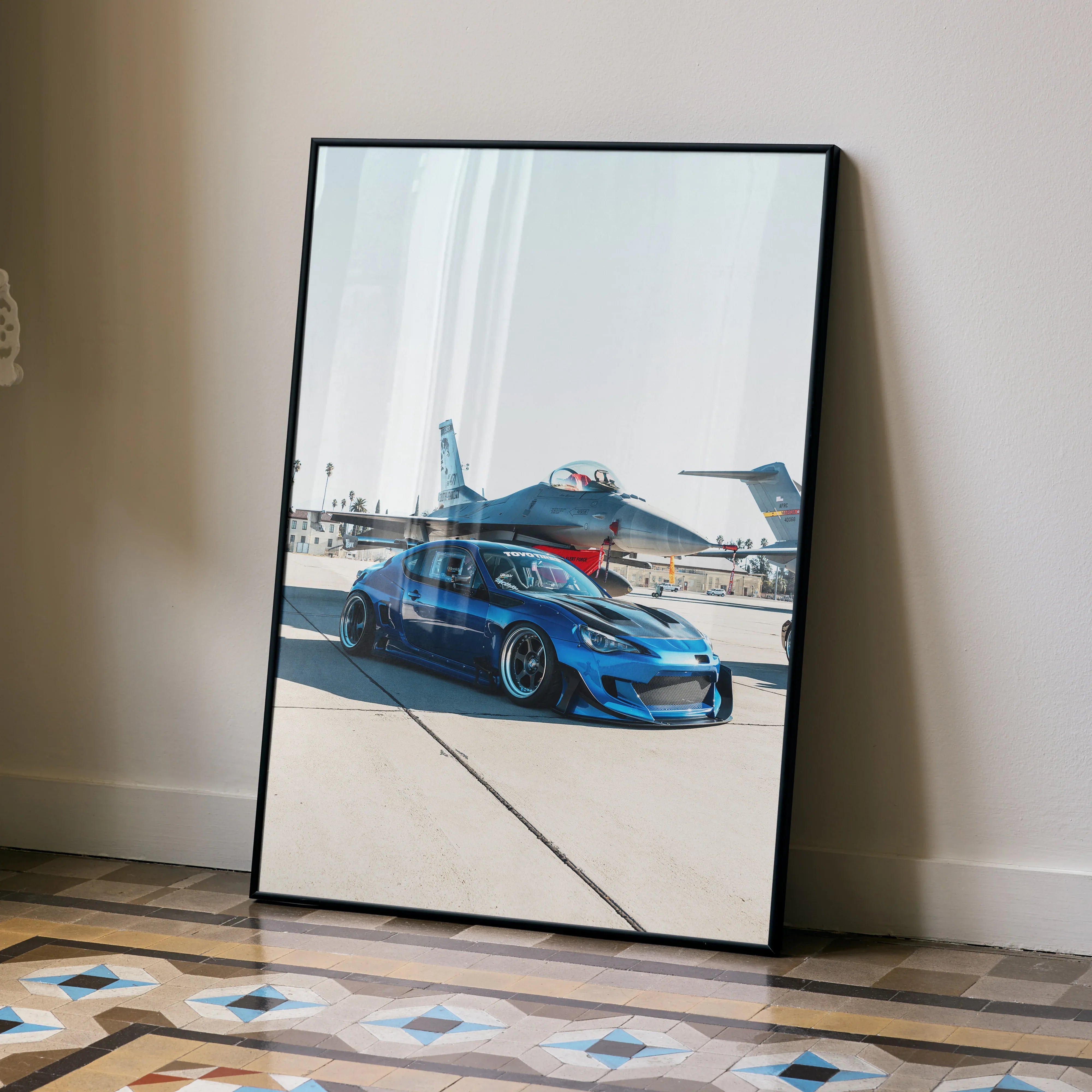 Sleek modified blue Toyota FRS poster leaning on wall showing sporty car and airplane runway wall art.