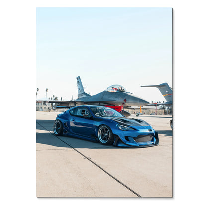 Sleek modified blue Toyota FRS parked on airstrip with fighter jets in background poster wall art.