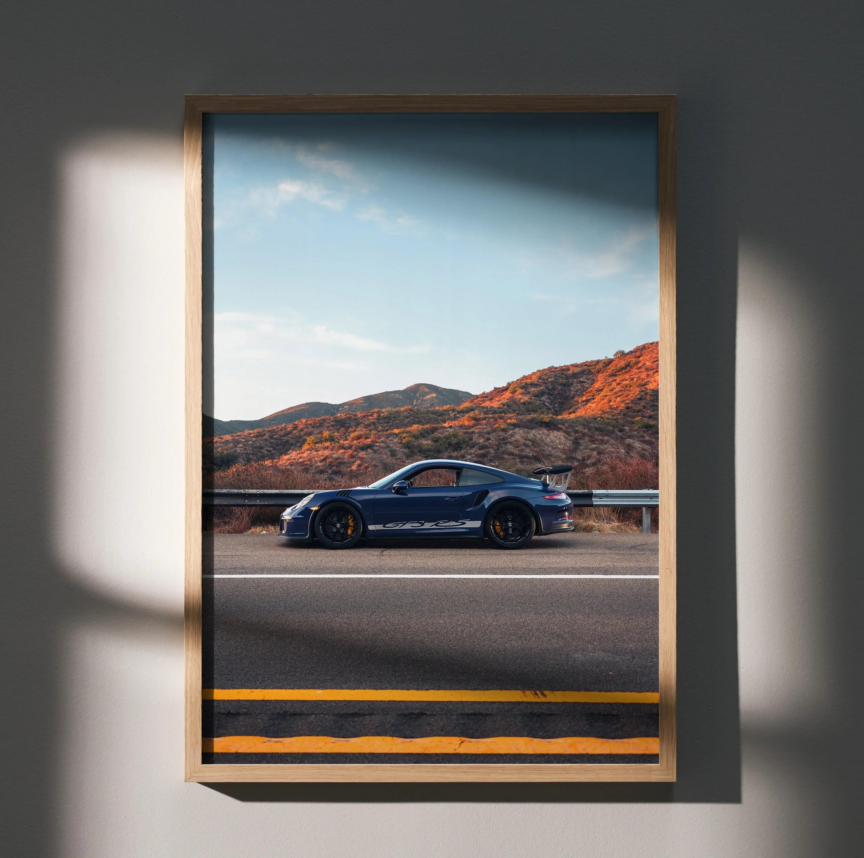 Porsche GT3 RS supercar in blue parked on desert road wall art poster with mountain backdrop.