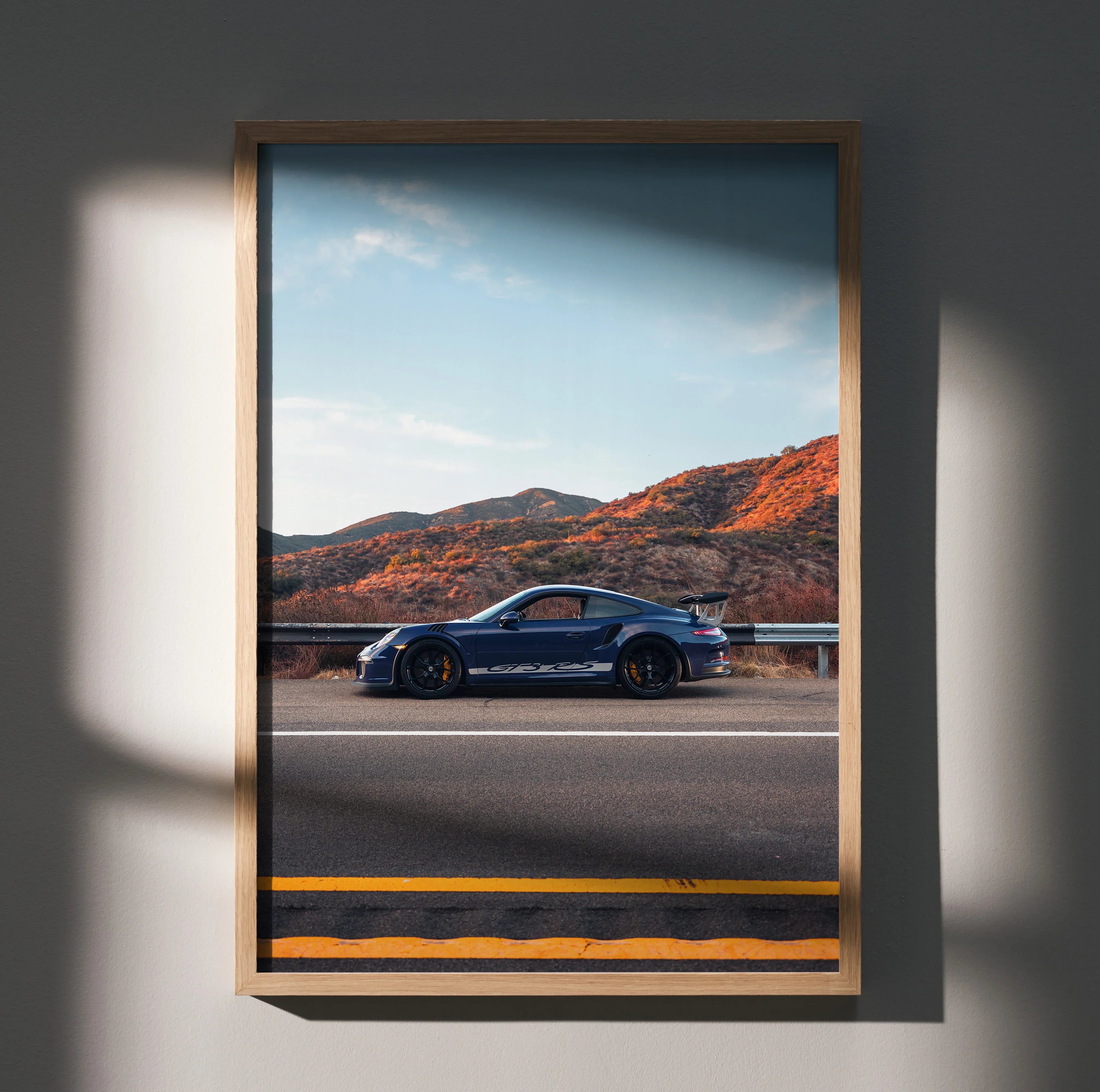 Porsche GT3 RS supercar in blue parked on desert road wall art poster with mountain backdrop.