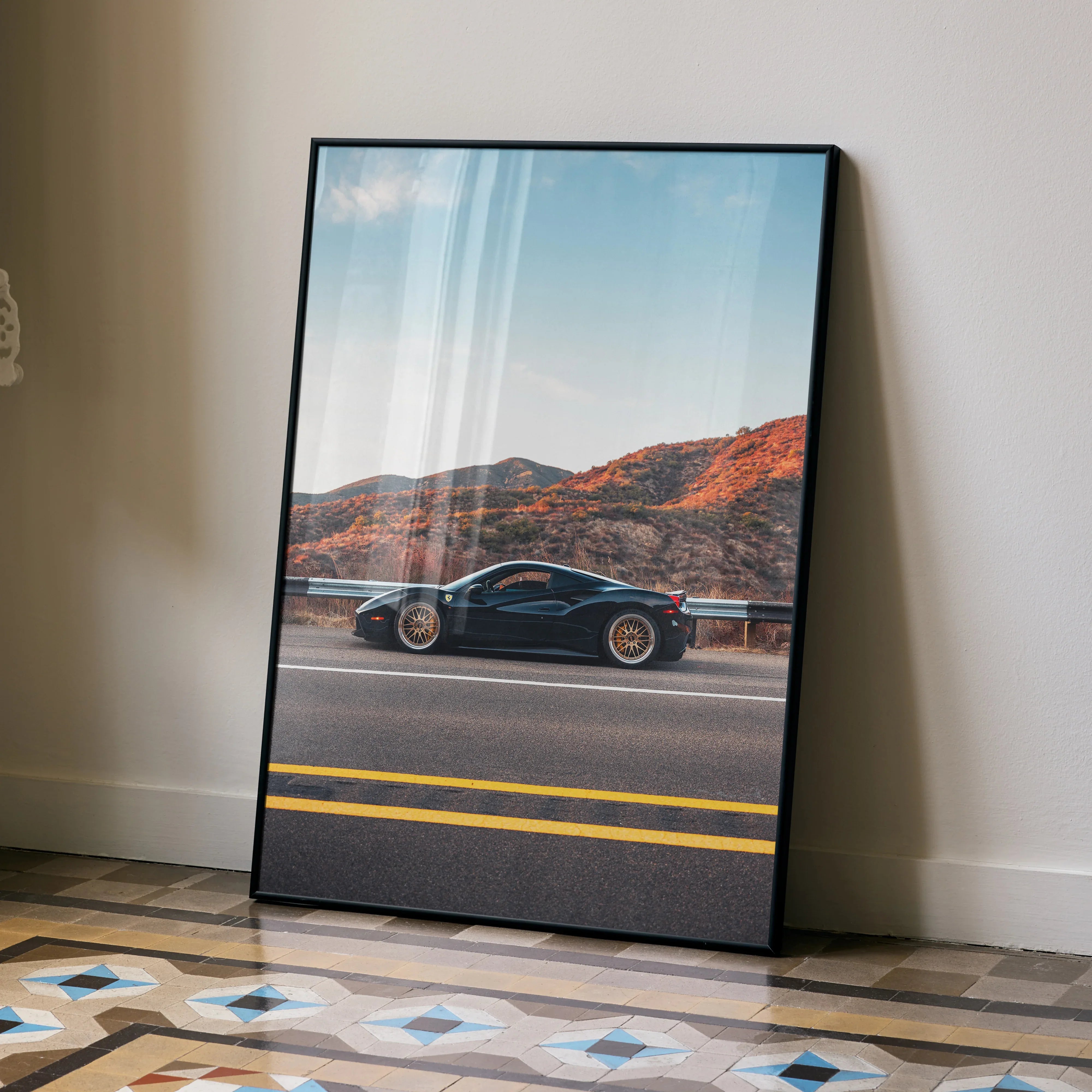 Sleek Ferrari 488 GTB poster leaning against wall with desert mountain backdrop, vibrant wall art.