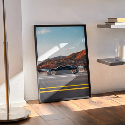 Sleek black Ferrari 488 GTB poster leaning against wall with desert landscape background, modern wall art.