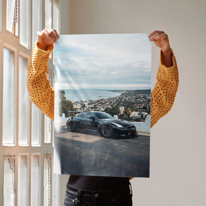 Nissan GTR R35 parked on scenic coastal road poster wall art with clear sky background.