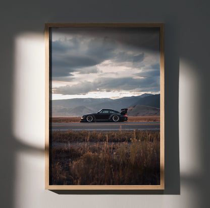 RWB Porsche 911 poster wall art with dark car silhouette on open road and dramatic cloudy sky.