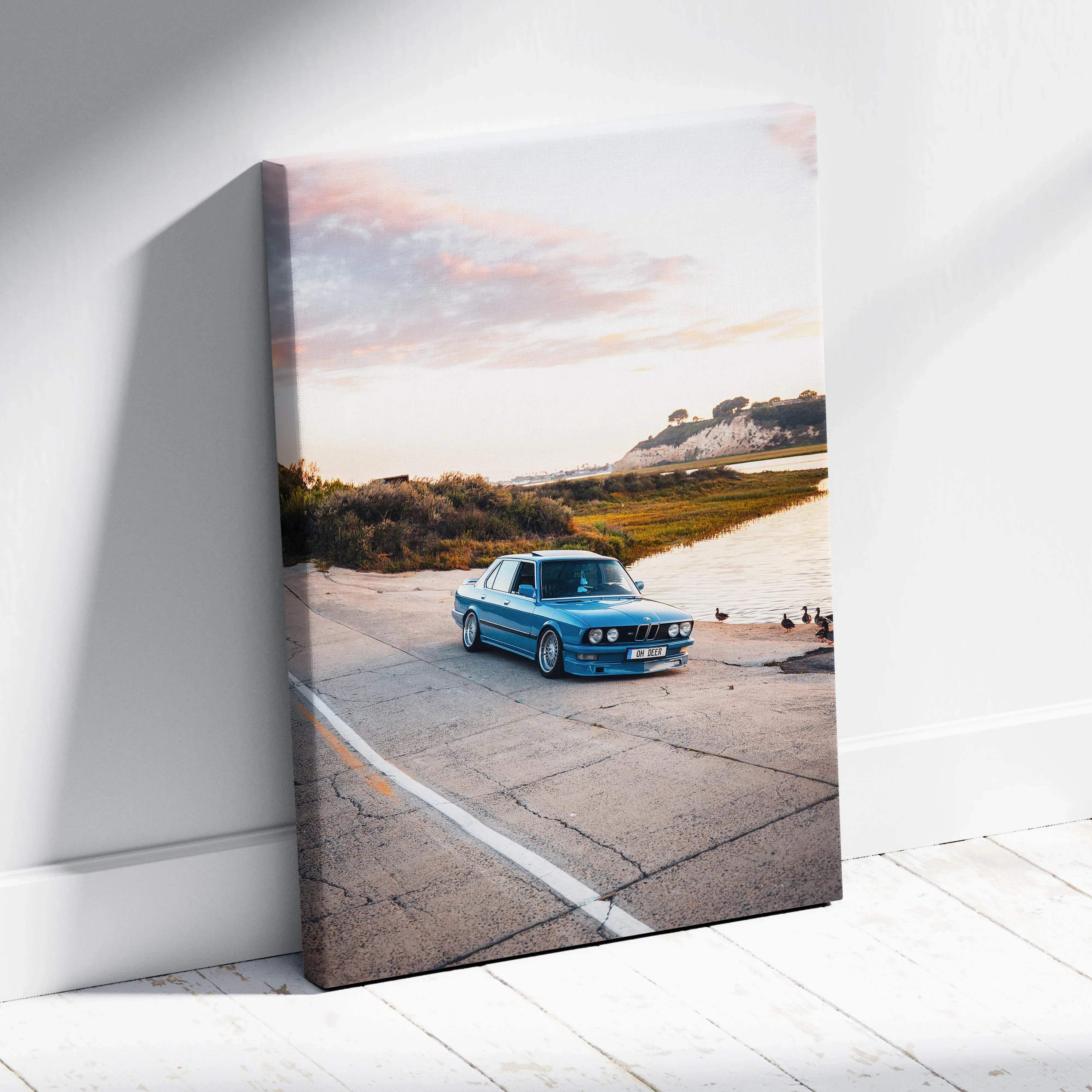 Canvas wall art featuring a blue bmw e30 sedan classic car print in a coastal sunset mood design