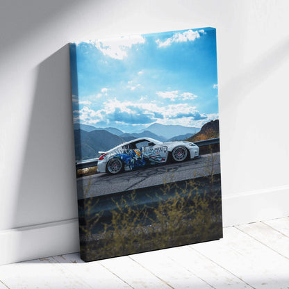 Vertical canvas wall art featuring Nissan 370z racing car on mountain road under blue sky.