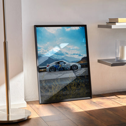 Nissan 370z widebody JDM car poster leaning against wall with mountain landscape background, framed wall art in modern room.