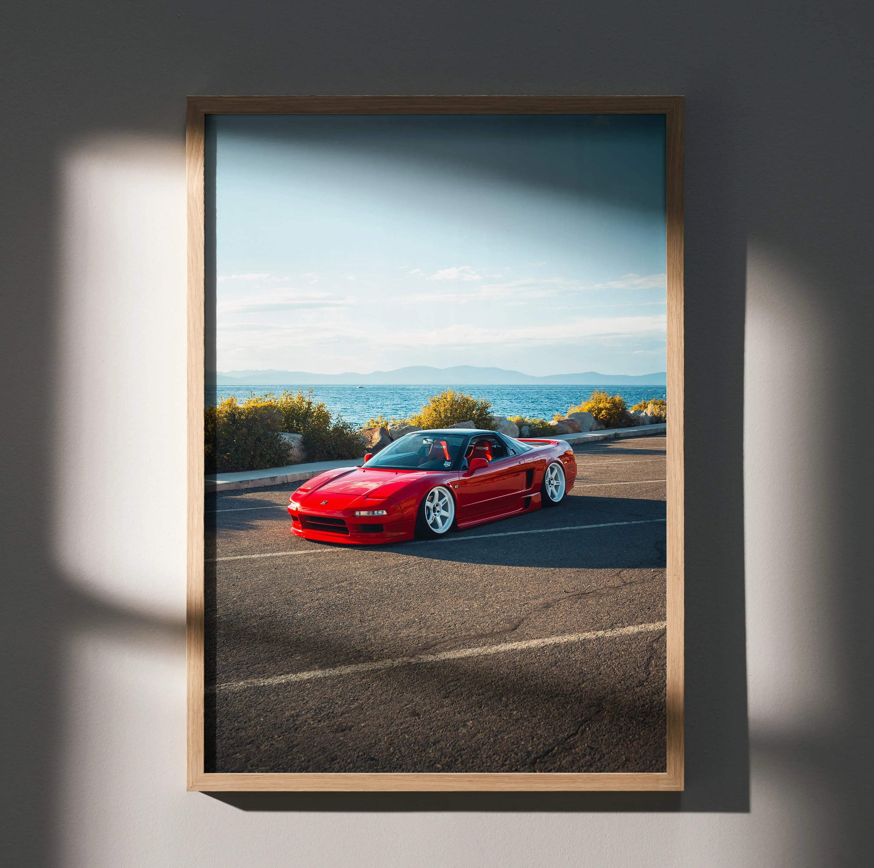 Red Acura NSX sports car parked on asphalt under blue sky in framed poster wall art.