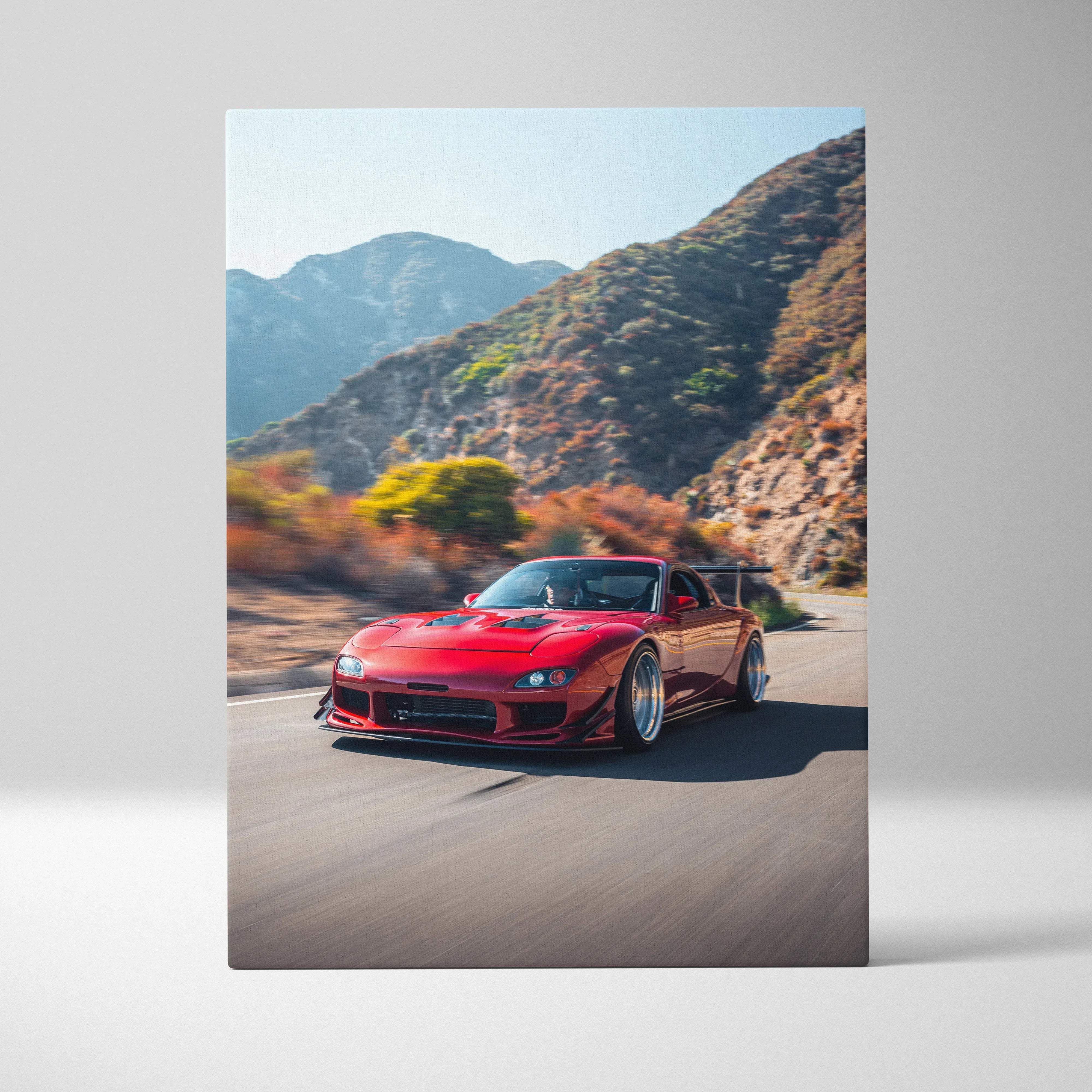 Canvas wall art featuring a vibrant red modified mazda rx-7 sports car with custom alloy wheels on a scenic mountain road