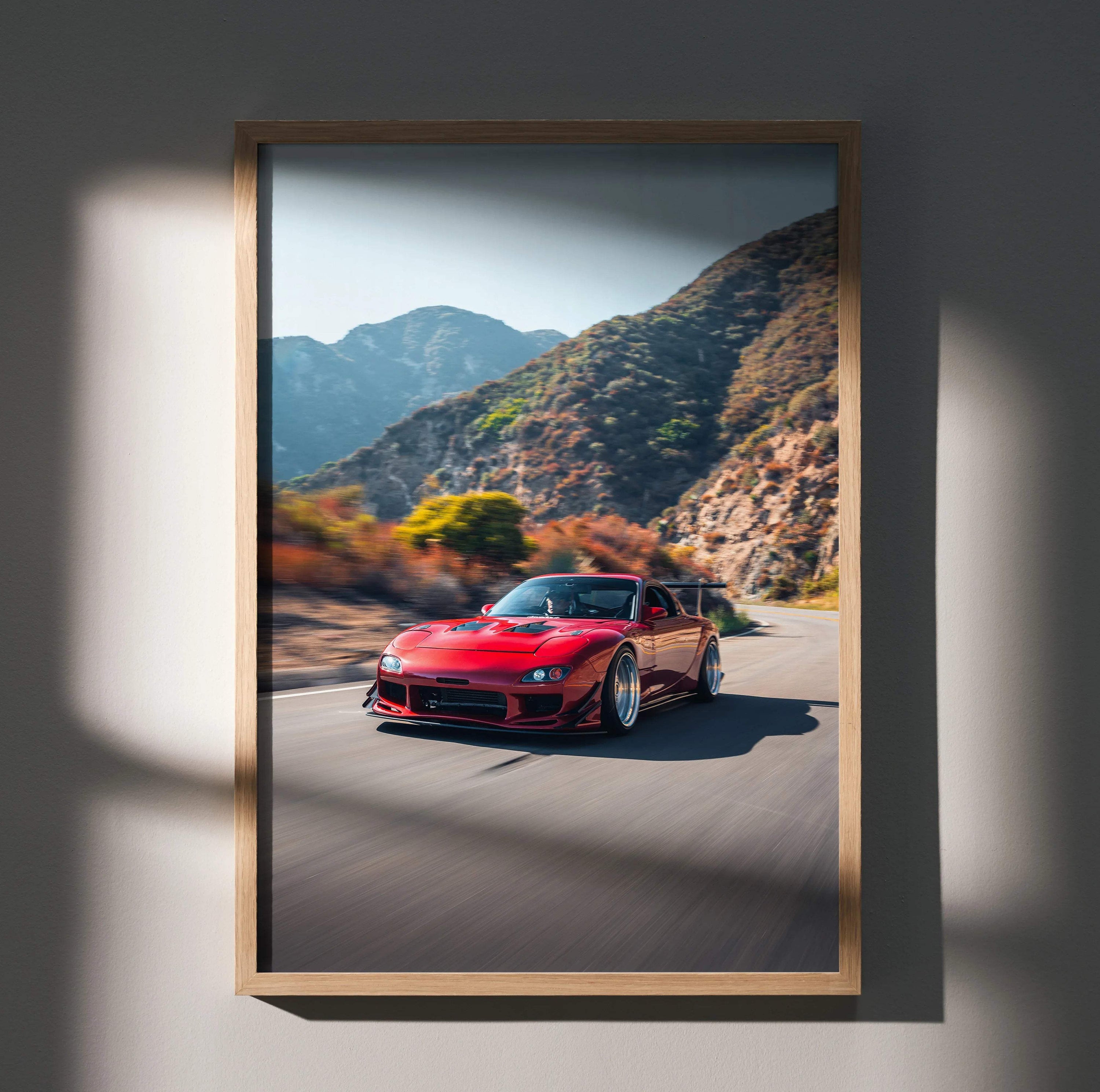 Mazda FD RX7 red sports car on mountain road wall art poster in wooden frame.