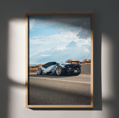 Lamborghini Huracan poster wall art with sleek white and black car on open road under blue sky.