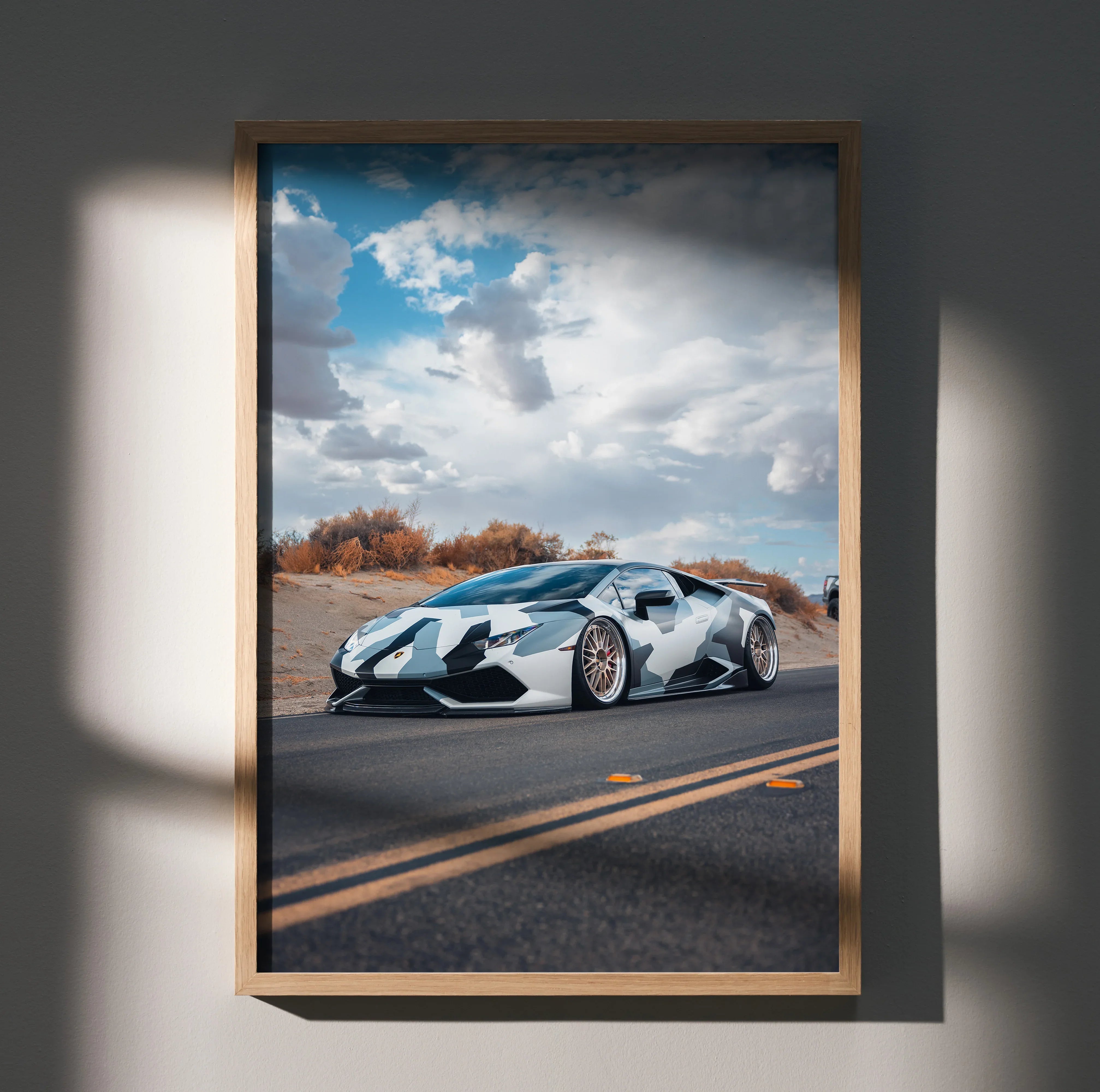 Lamborghini Huracan poster featuring a sleek silver sports car on a road under a dramatic cloudy sky, wall art in a wooden.