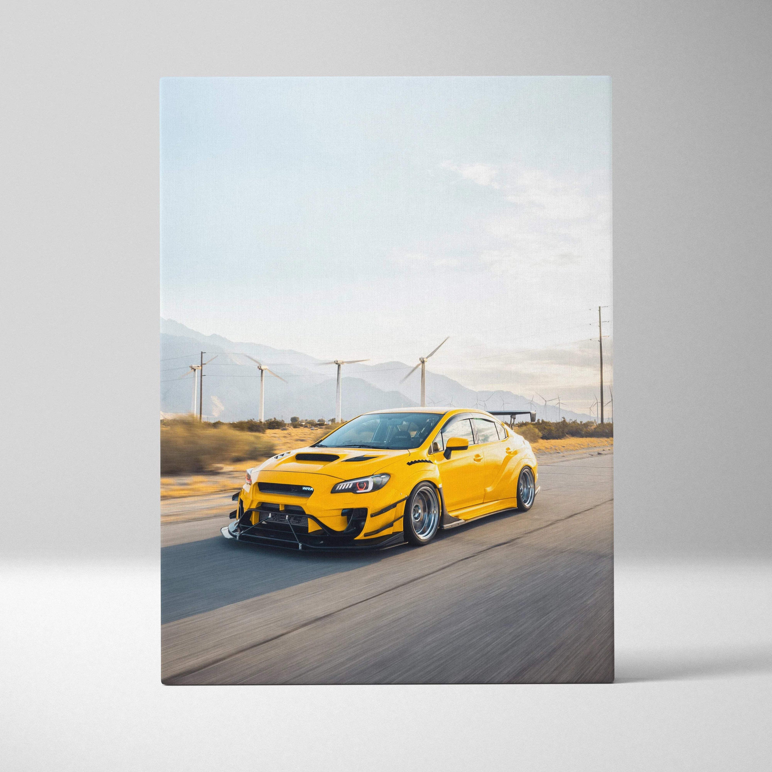 Yellow Subaru WRX STI driving on highway with wind turbines in background canvas wall art.