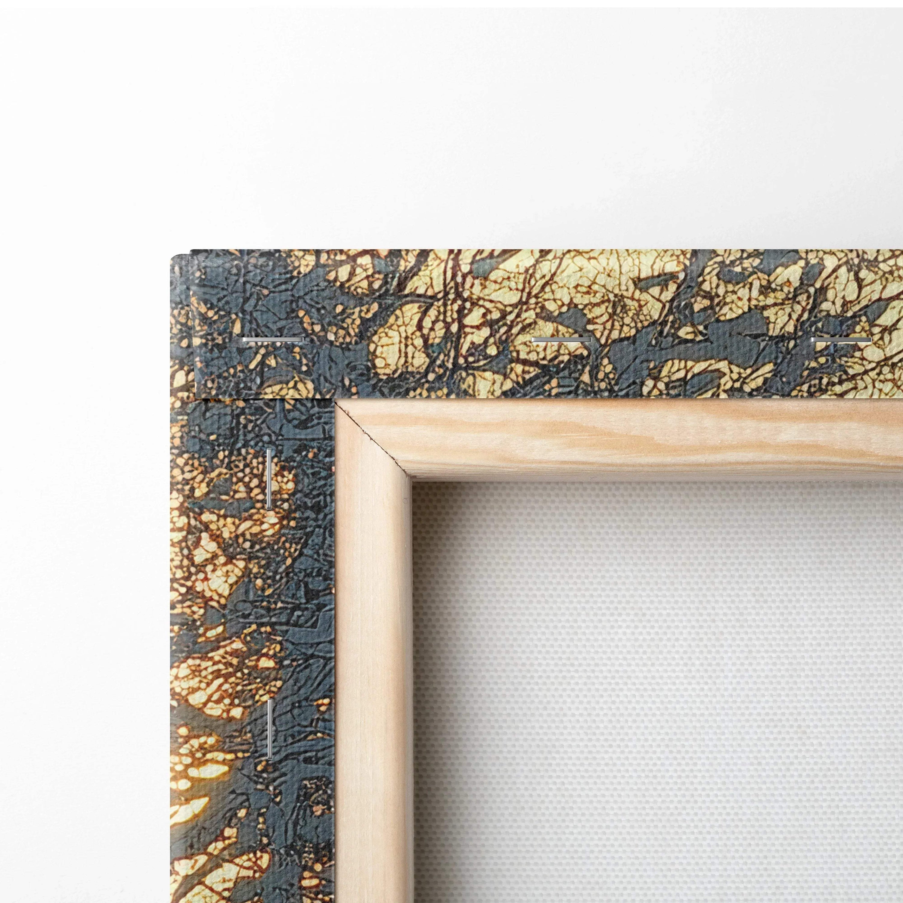 Close-up of canvas wall art corner with black and gold textured frame and natural wood inner trim.