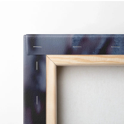 Close-up of canvas wall art corner with wooden frame and dark snowy mountain town print.