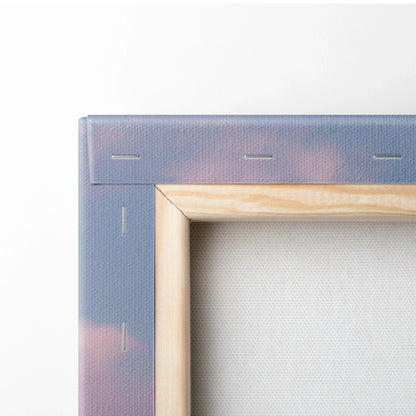 Close-up of canvas wall art stretched on wooden frame with faded pink and purple minimalist desert dunes decor.