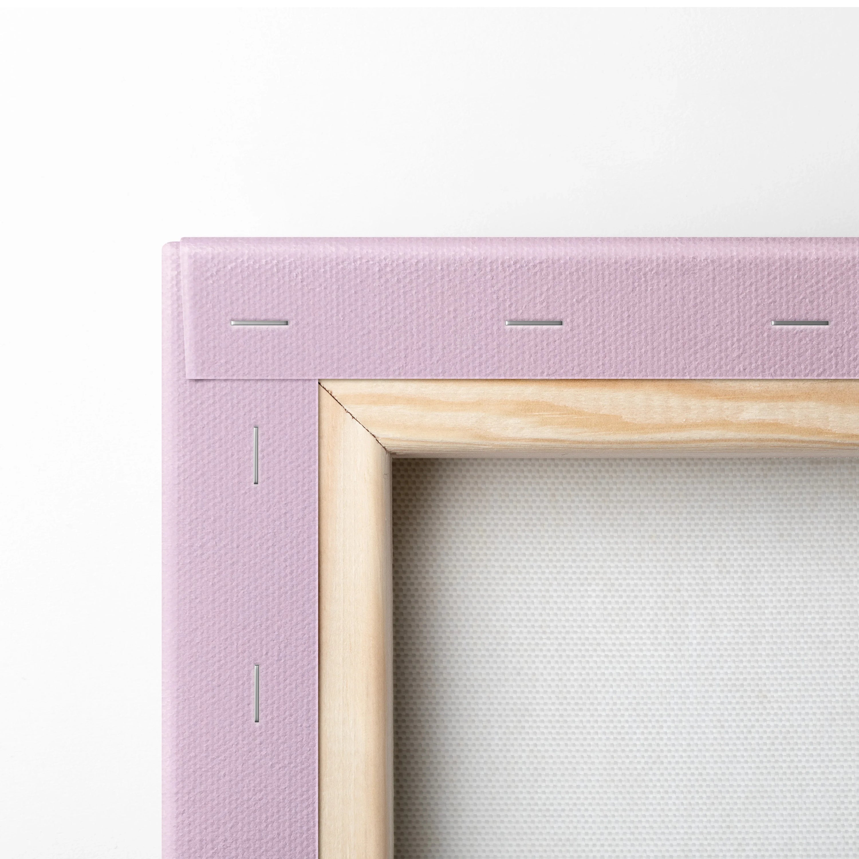 Close-up of pink stretched canvas wall art corner with natural wood frame and stapled edges for home decor.