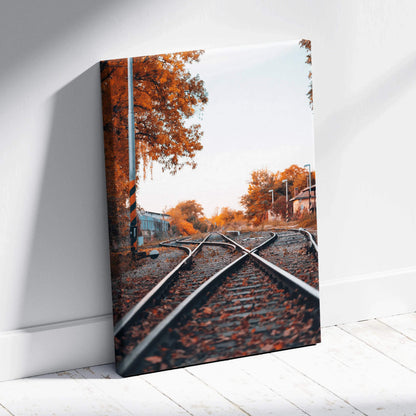 Autumn railway tracks with vibrant orange trees on vertical canvas wall art print.