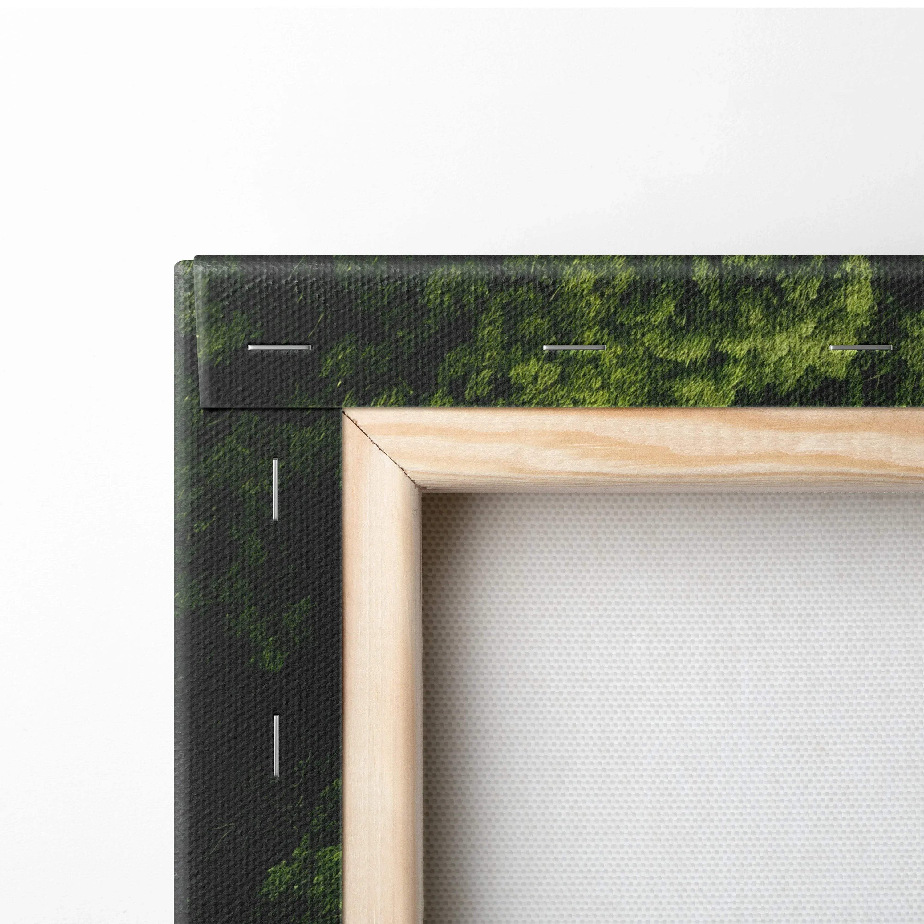 Close-up of stretched canvas wall art with a wooden frame, featuring a green forest landscape print.