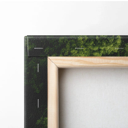 Close-up of stretched canvas wall art with a wooden frame, featuring a green forest landscape print.