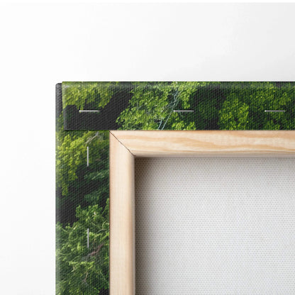 Close-up of wooden frame corner on canvas wall art showing green forest and river decor details.
