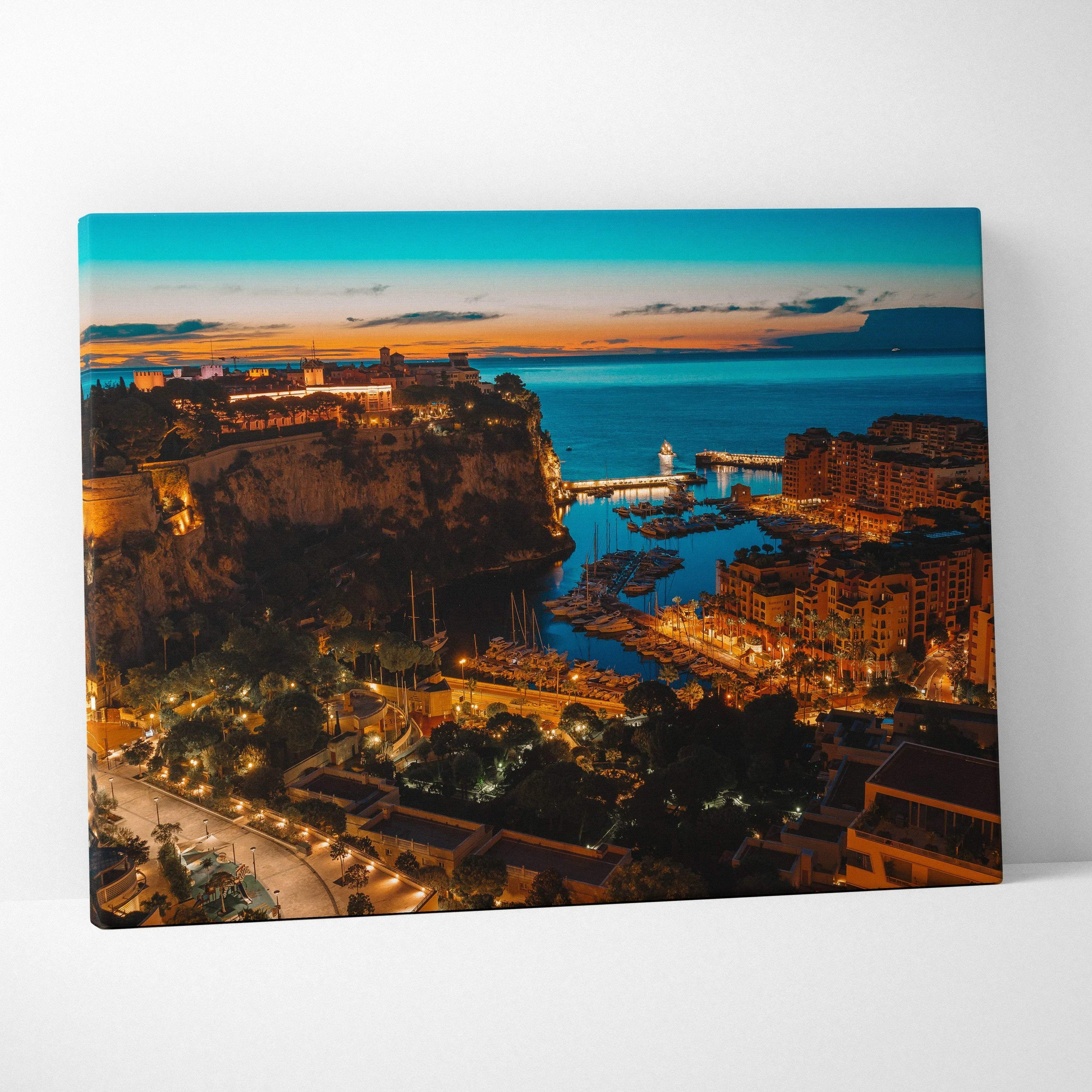 Canvas wall art print featuring a vibrant nighttime cityscape with illuminated buildings and a coastal harbor under a deep.