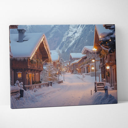 Canvas print of a snowy winter village street with wooden houses and warm glowing lights at dusk.