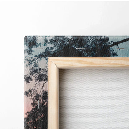Close-up of forest sunset canvas wall art corner with natural wood frame and vibrant nature scene decor.