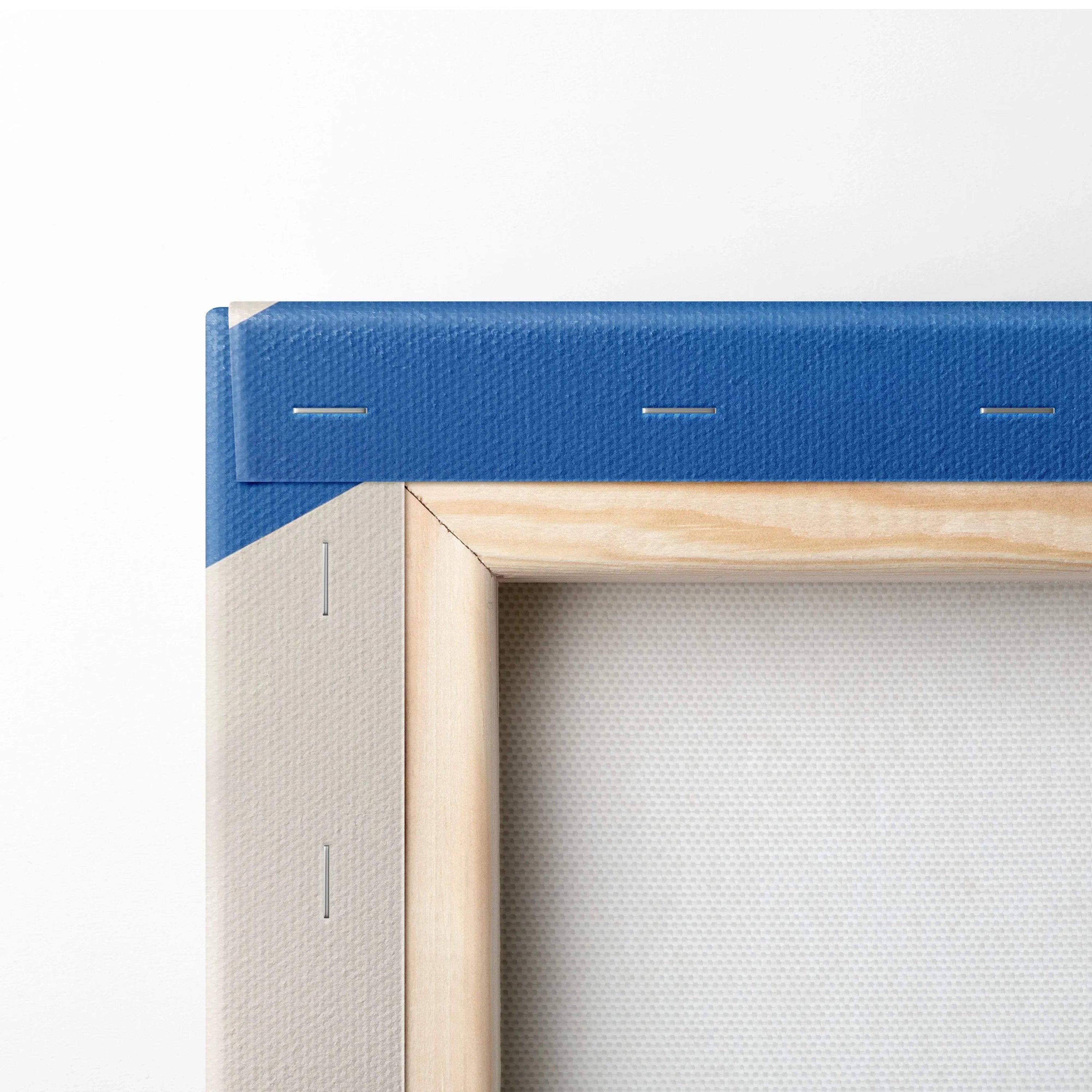 Corner close-up of blue stretched canvas wall art with wooden frame and visible staples.