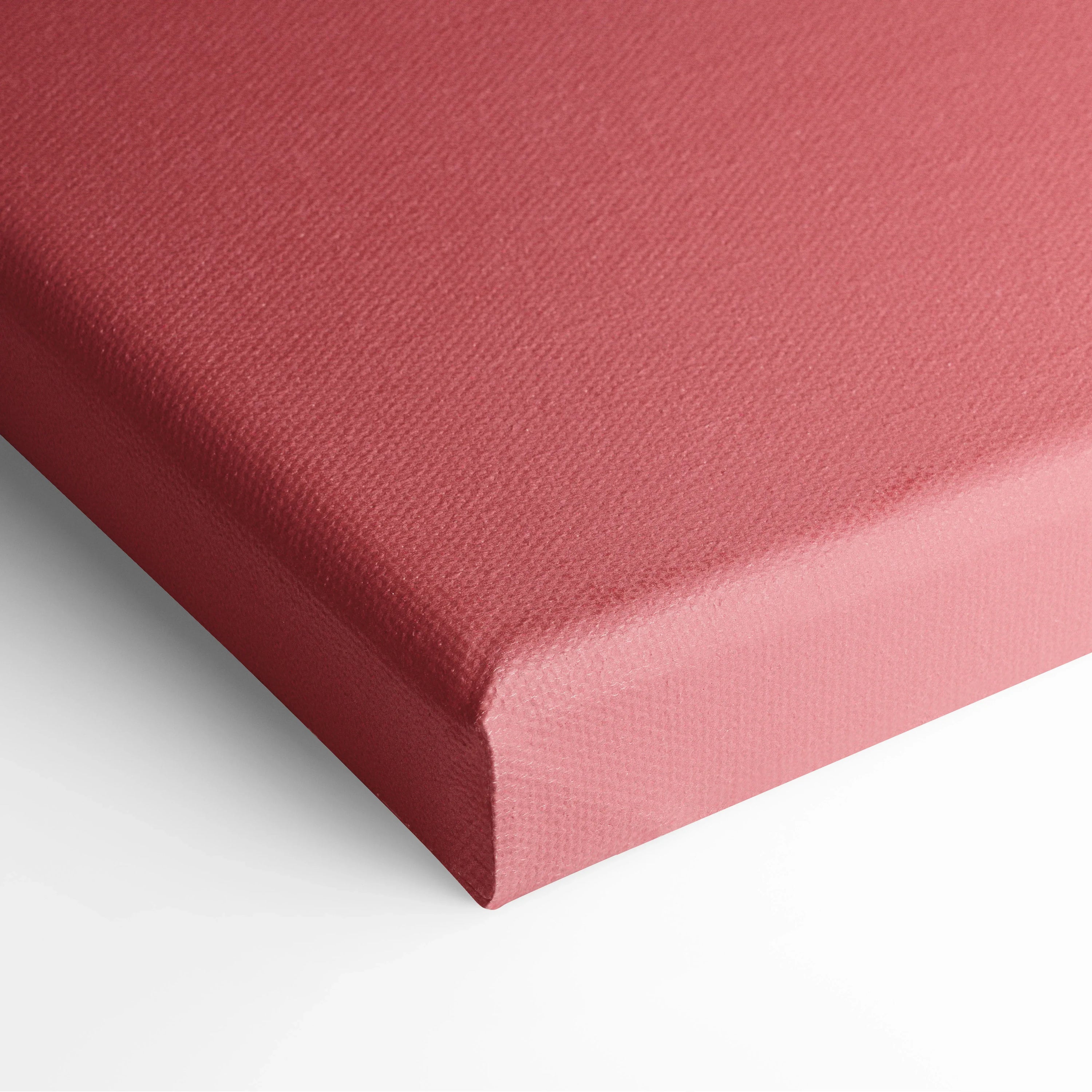 Close-up of canvas wall art with textured surface in solid dusty rose color wrapped around a thick wooden frame.