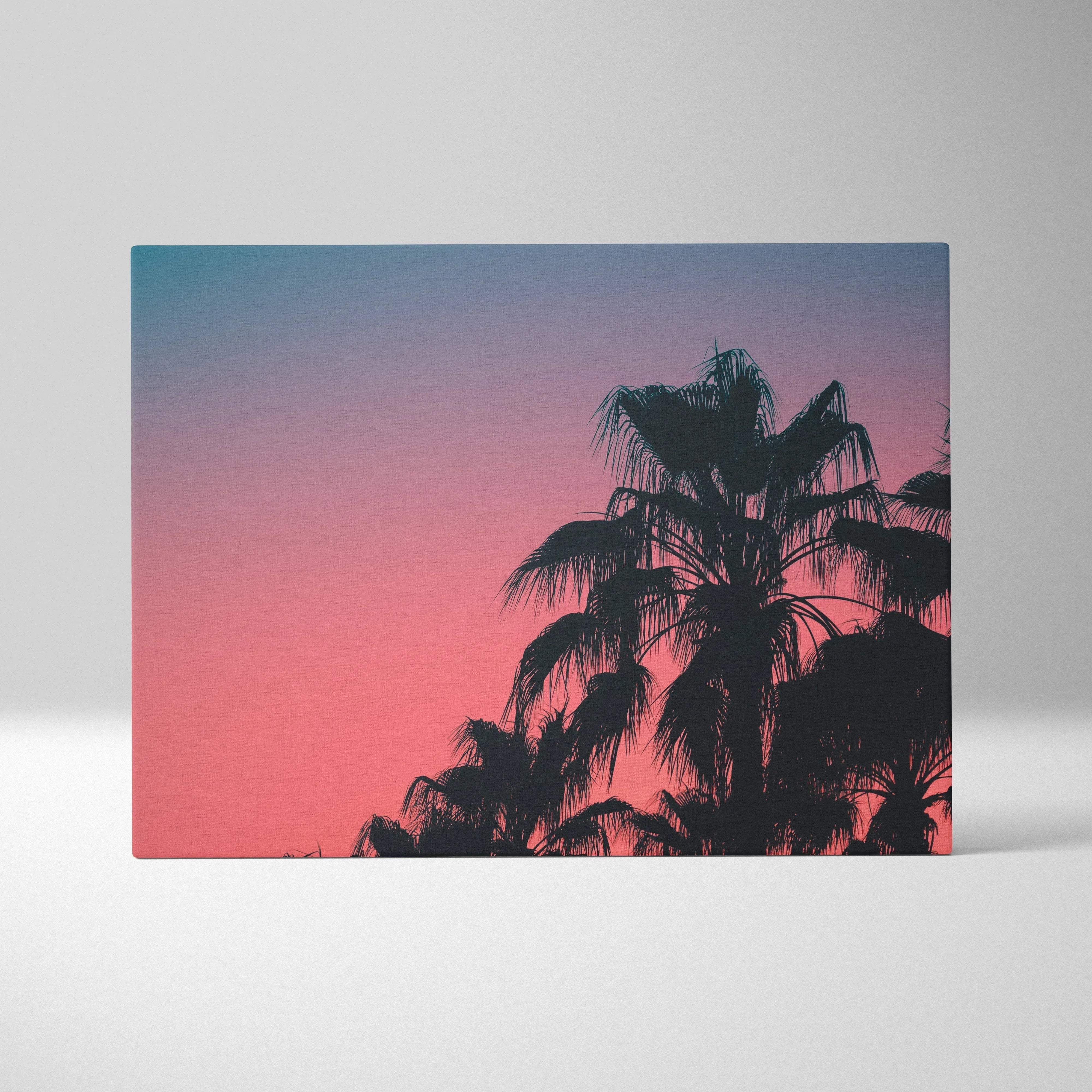 A rectangular canvas print of tropical palm silhouettes against a teal to coral sunset gradient sky for wall art decor