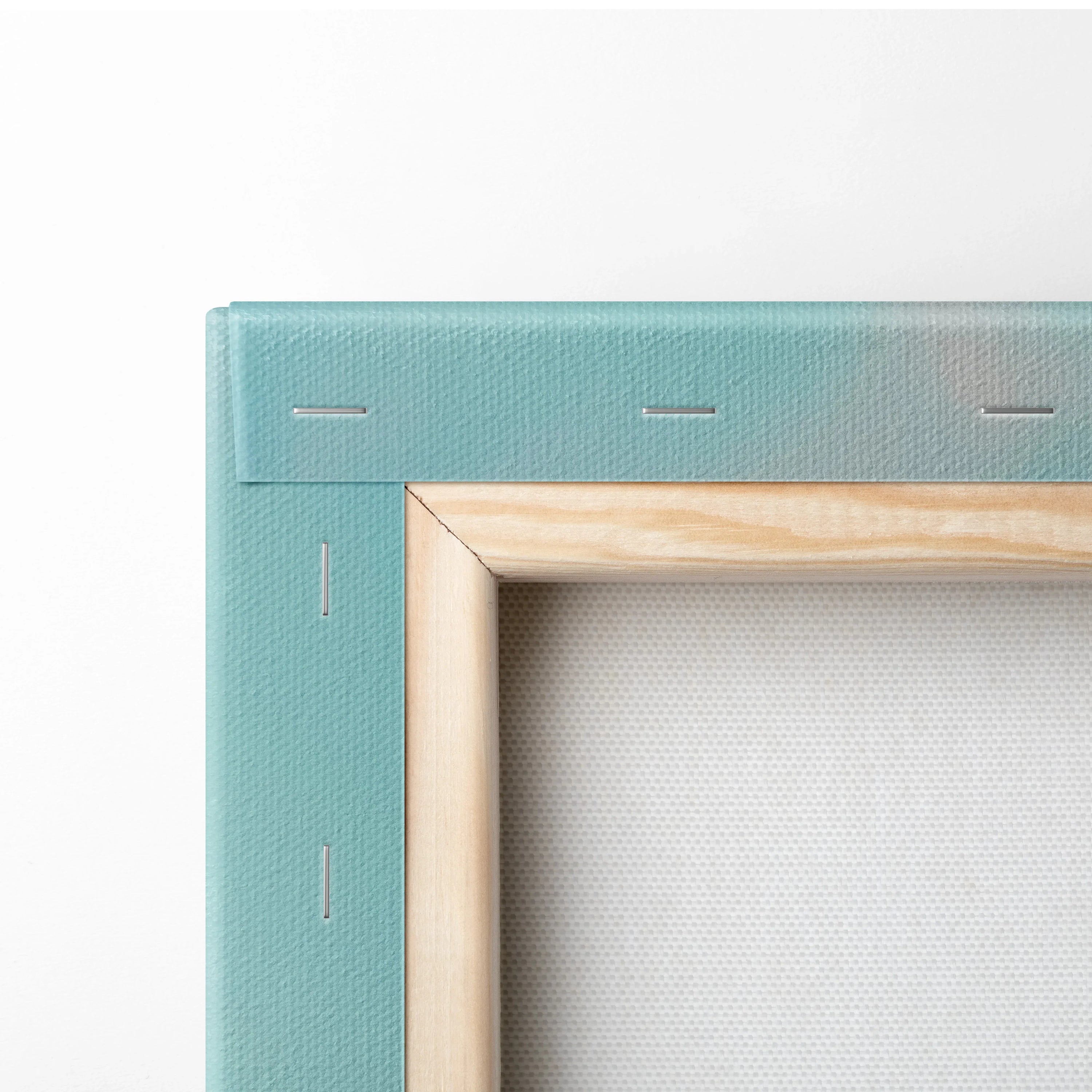 Close-up of light blue stretched canvas with wooden frame and visible staples on edges.