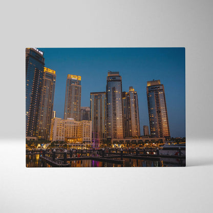 Canvas wall art print featuring illuminated modern skyscrapers at dusk with a deep blue sky background.