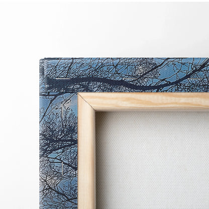 Close-up of canvas art with a natural wood frame featuring detailed tree branches against a blue sky wall art.