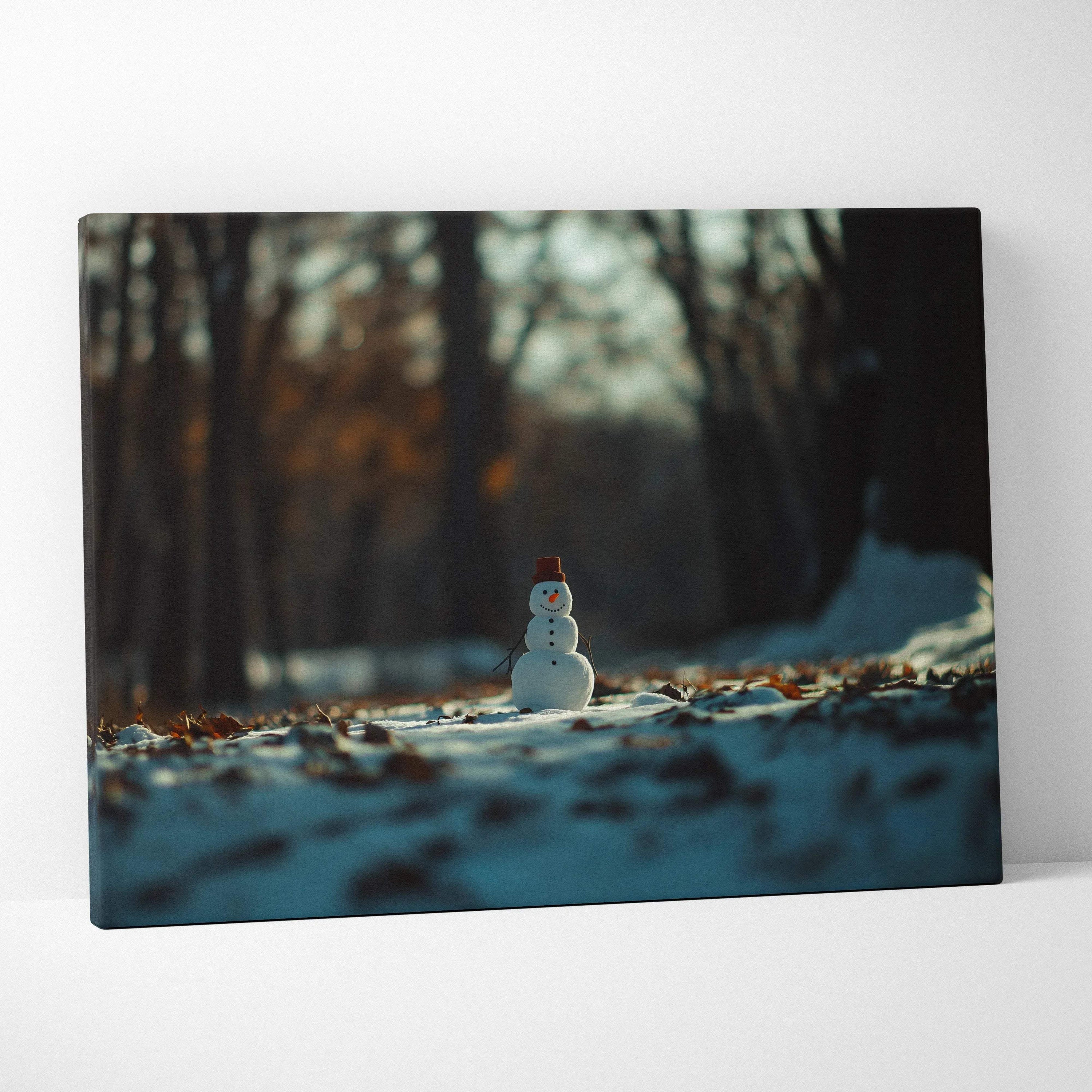 Canvas wall art featuring a small snowman in a snowy forest with dark, blurred trees in the background.