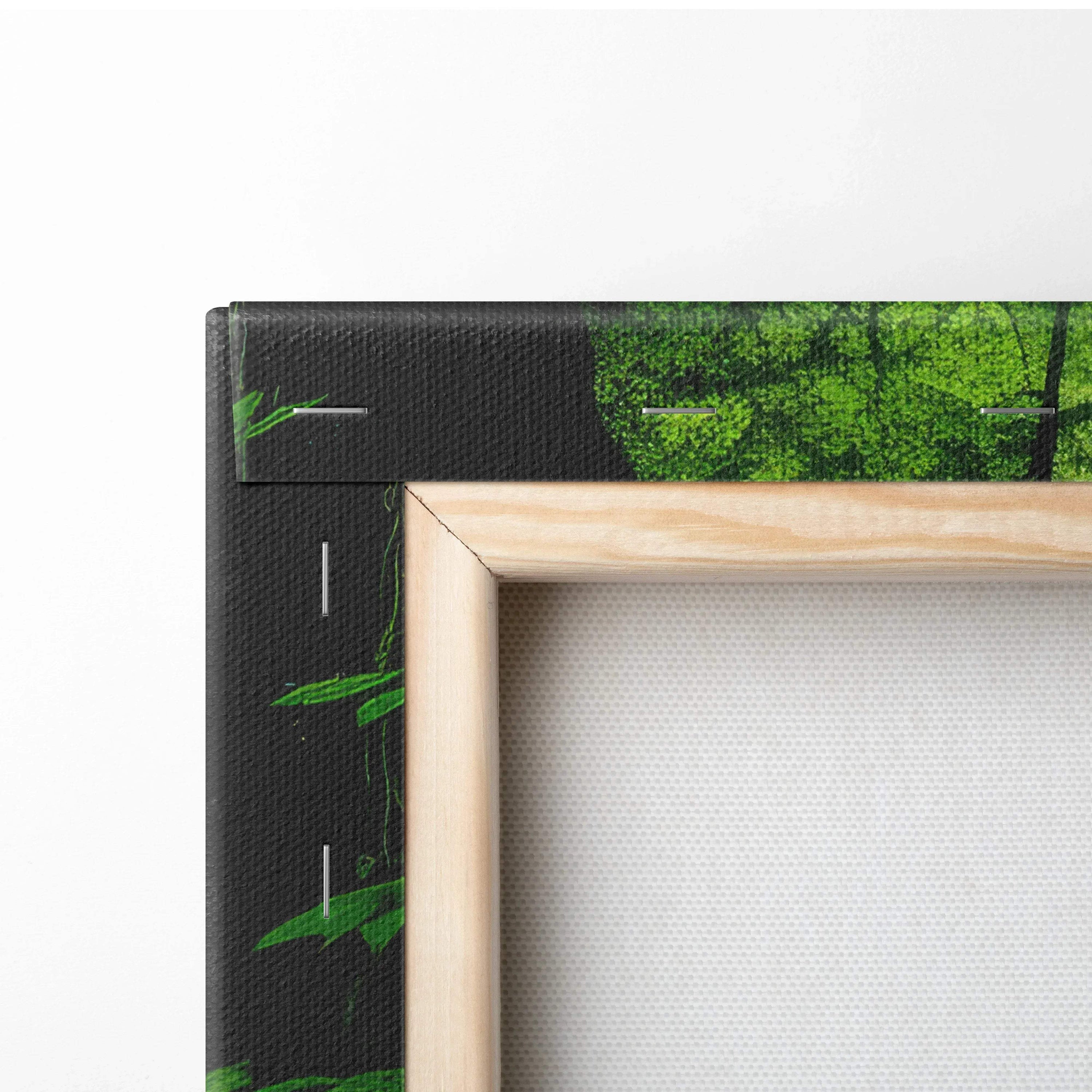 Corner detail of canvas wall art with wooden frame featuring lush green forest foliage decor.