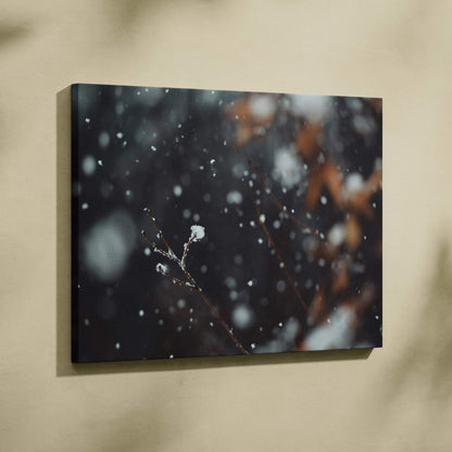 Canvas wall art featuring a dark winter landscape with snowflakes falling softly on delicate branches, accented with subtle.