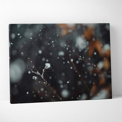 Canvas wall art featuring a dark, moody winter scene with blurred snowflakes and delicate snow-covered branches.
