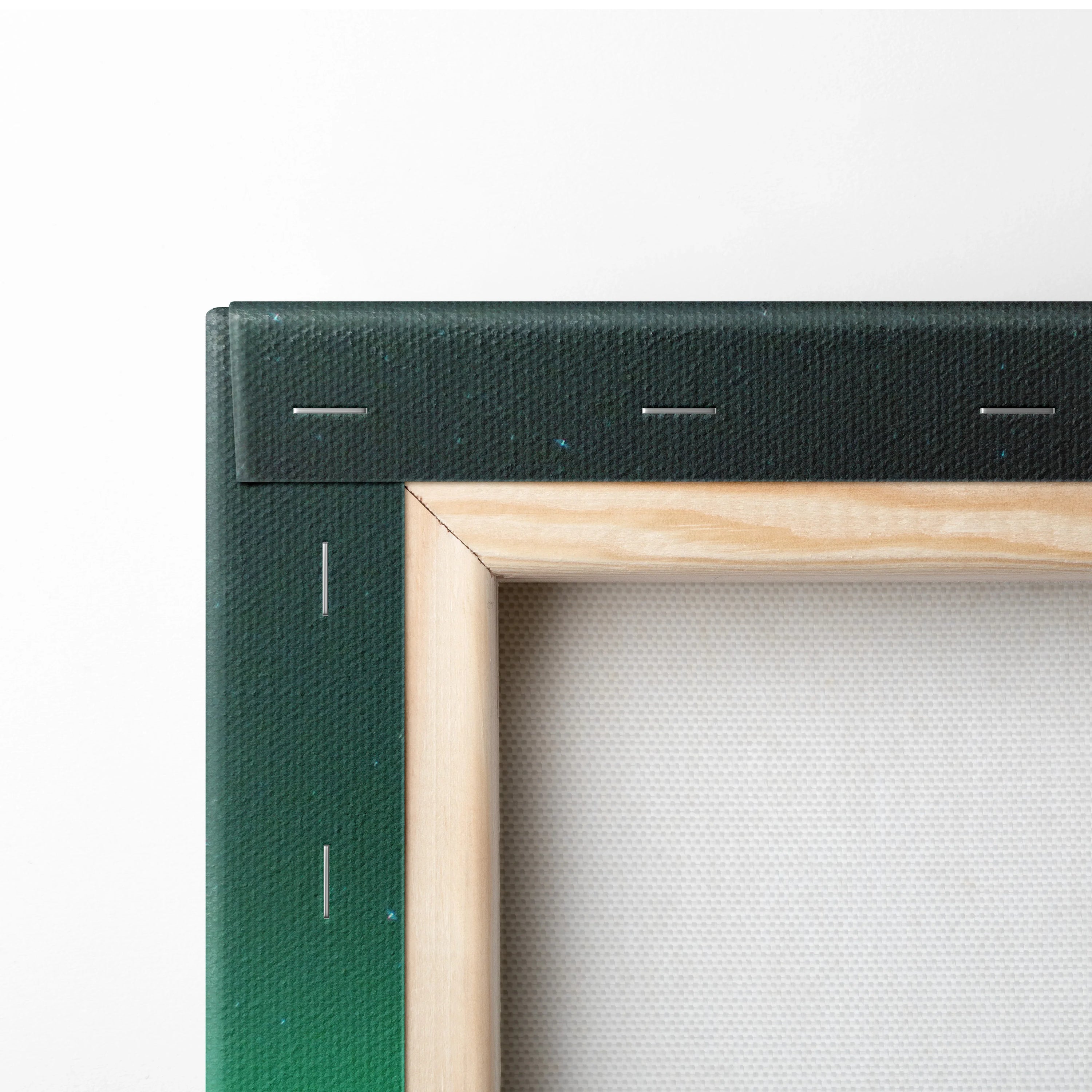 Close-up of canvas wall art corner with green gradient fabric wrapped around wooden frame and visible staples.