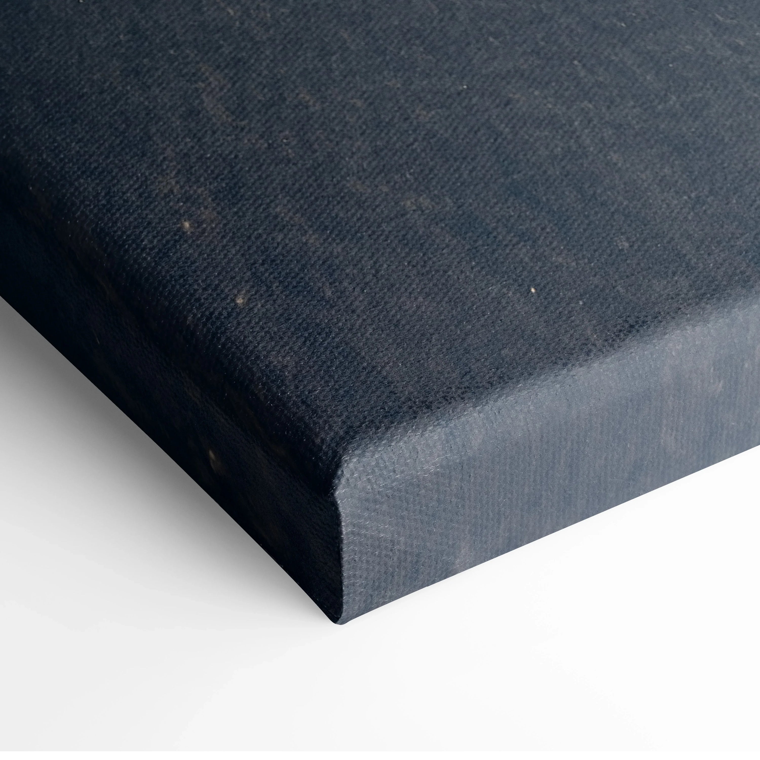 Close-up of dark blue textured canvas material wrapped around a wooden frame for wall art decor.