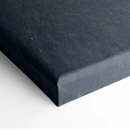Close-up of dark blue textured canvas material wrapped around a wooden frame for wall art decor.