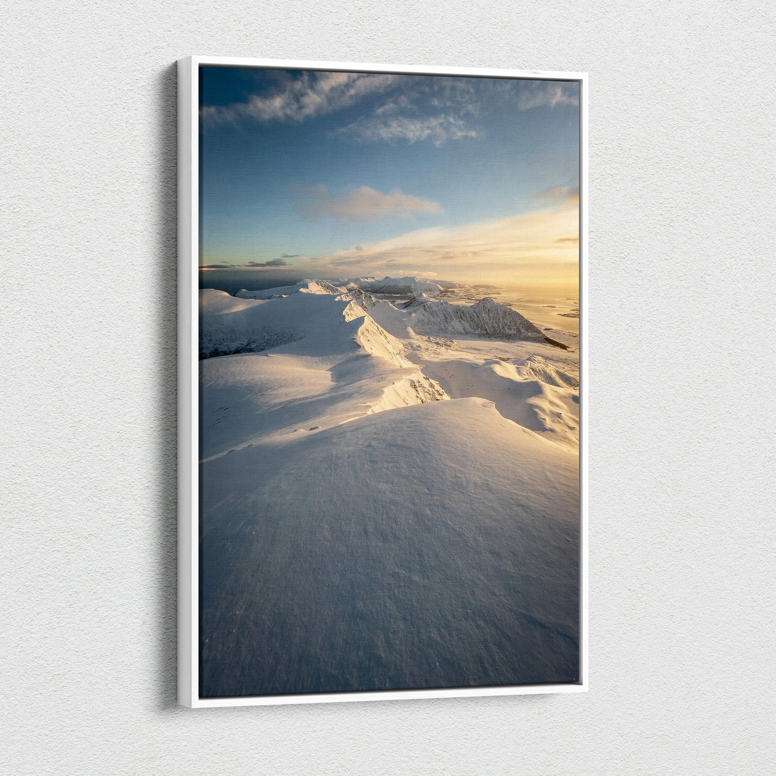 Canvas wall art featuring snow-covered Norwegian mountains under a blue sky with soft golden sunlight.
