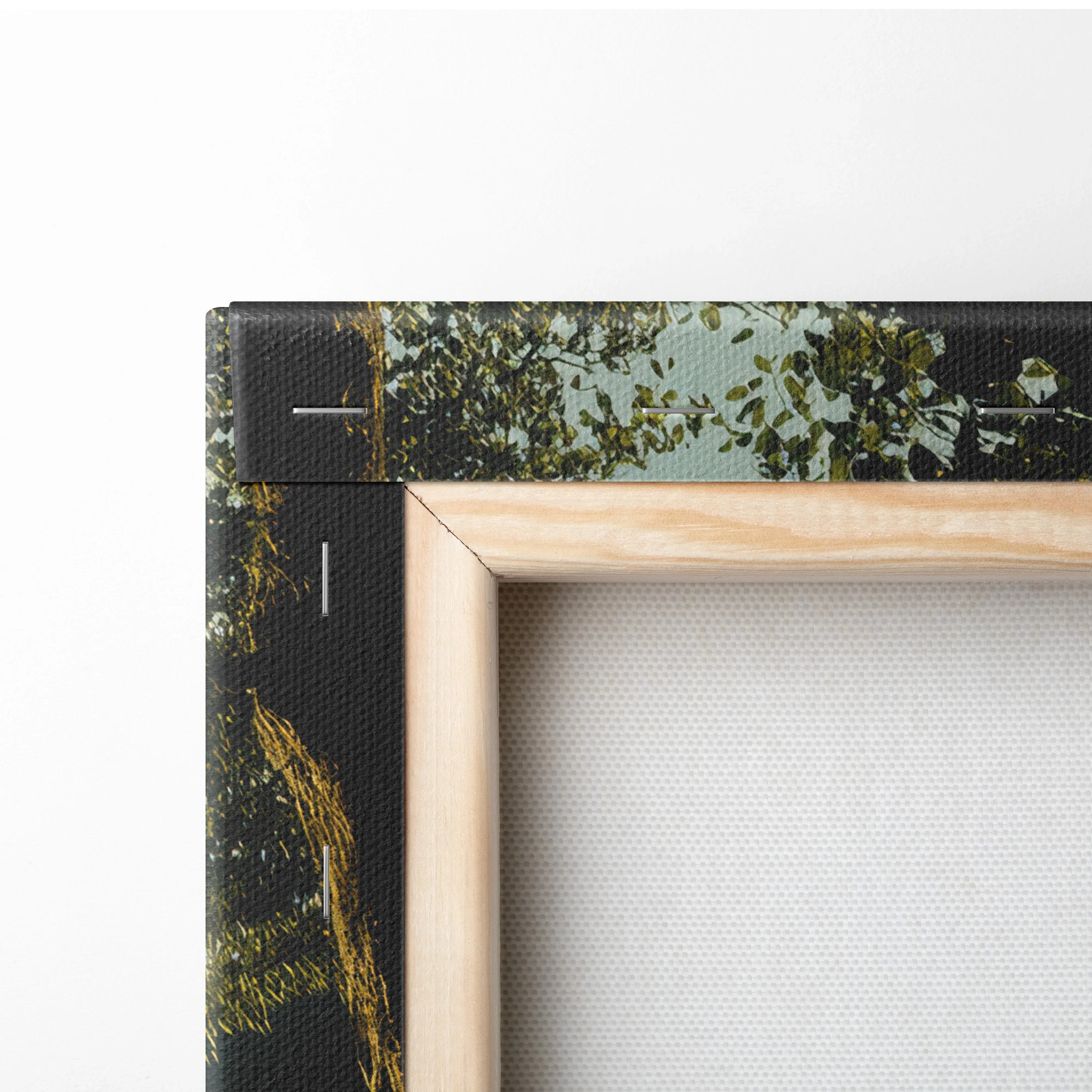 Close-up of wooden frame corner with forest sunset mountain scene printed on canvas wall art decor.