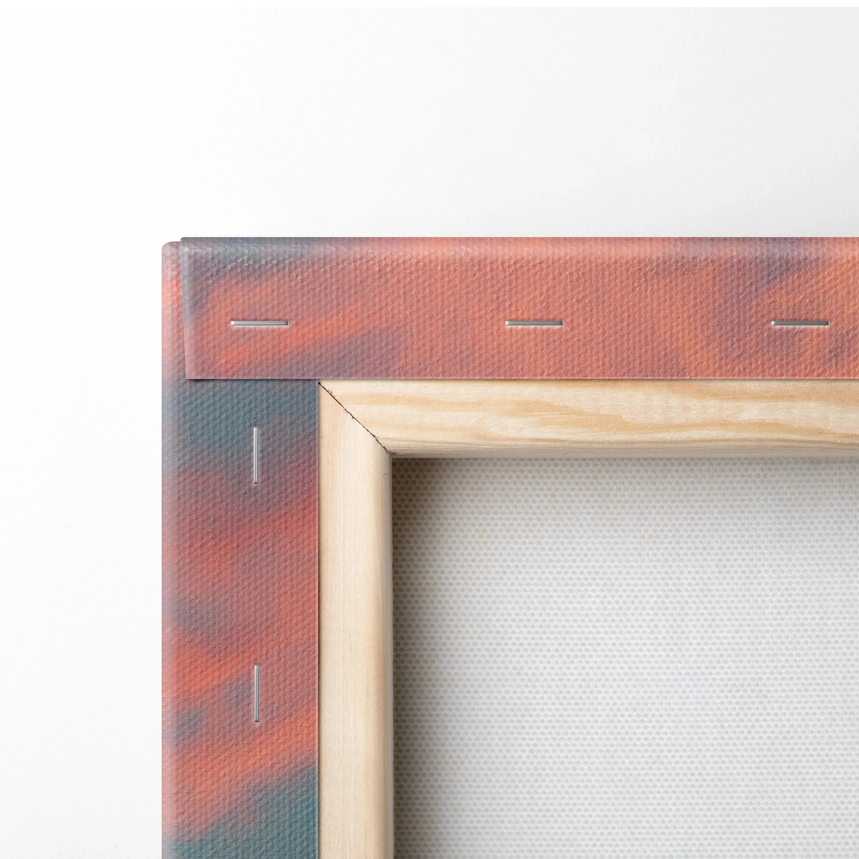 Close-up of stretched canvas with wooden frame showing tropical sunset colors in red and orange tones on wall art decor.