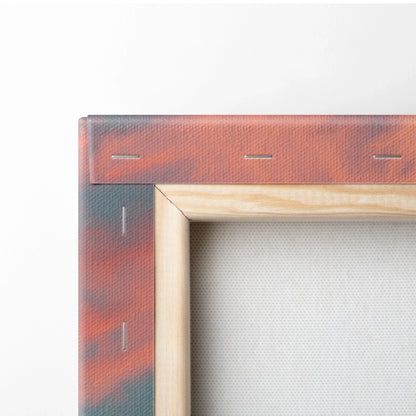 Close-up of stretched canvas with wooden frame showing tropical sunset colors in red and orange tones on wall art decor.