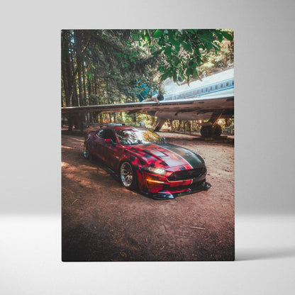 Vertical canvas art wall print featuring a red Ford S550 Mustang parked in a forest setting under sunlight beams.
